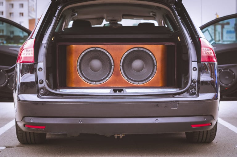 Car with its trunk open with two subwoofers showing how subwoofers work